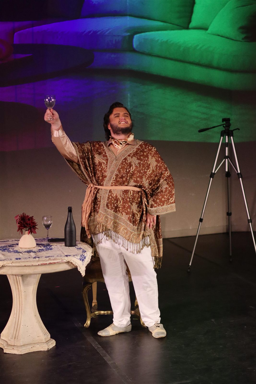 Rhys Stermer performing in a colorful stage scene.